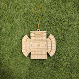 A wooden ornament resembling a football stadium is placed on a grassy surface.