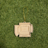 A wooden ornament resembling a stadium is placed on a grassy surface.